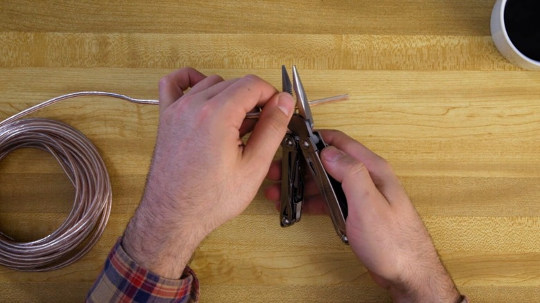 A multitool being used to cut copper.