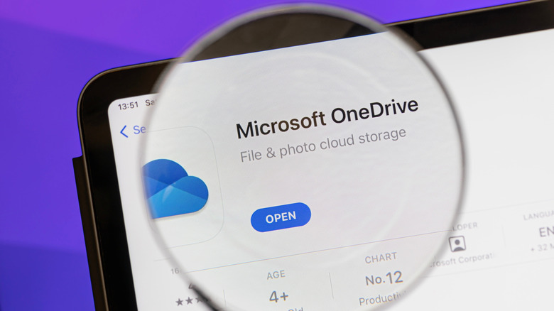 Microsoft OneDrive app on iPad screen viewed through a magnifying glass