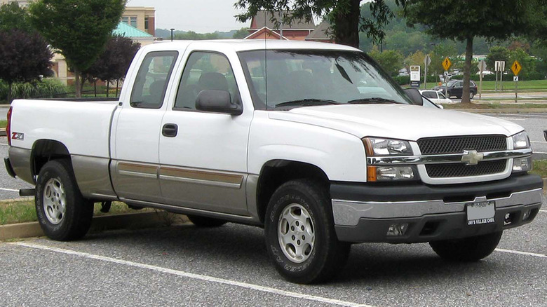 A white 2003 Chevy Silverado in a parking space