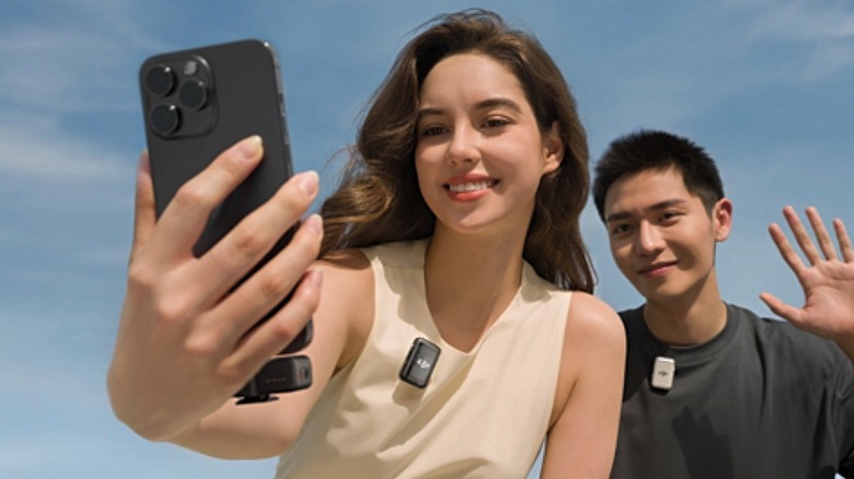 A woman recording herself and a friend with the DJI Mic 2 attached to her clothing.