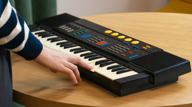 A typical cheap rompler, a synthesizer with a keyboard, a lot of buttons, and two speakers.