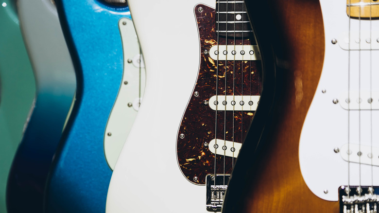Four different electric guitar bodies one in front of the other.