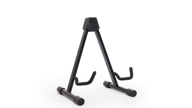 A typical guitar stand, black color,  with two arms to hold the instrument and two feet to stay uprigth.