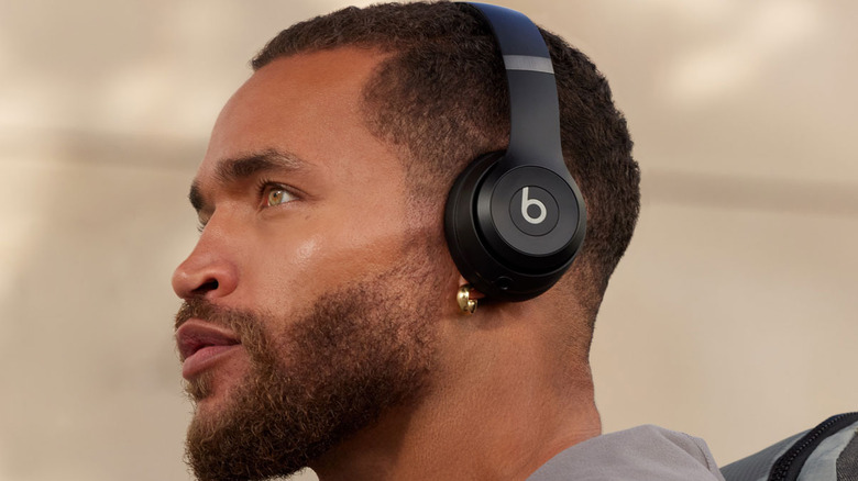 A person wearing a pair of Beats Solo 4 headphones, with a piercing