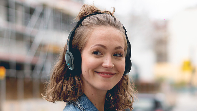 A person smiling while wearing the Creative Sound Blaster Jam V2 headphones