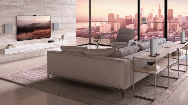 The four Sony Bravia Theater Quad speakers placed in a living room, two wall-mounted on either side of the television and the other two behind a couch on a table