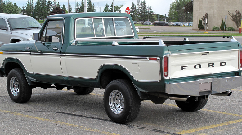 A green and white Ford F-150 in a parking spot