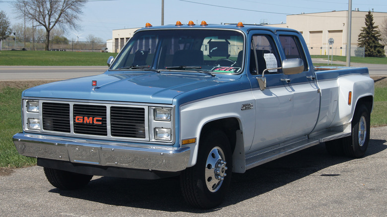 A GMC Sierra from 1986 parked by a large building