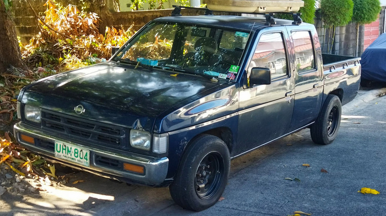 A dark blue Nissan D21 parked on a street in the suburbs
