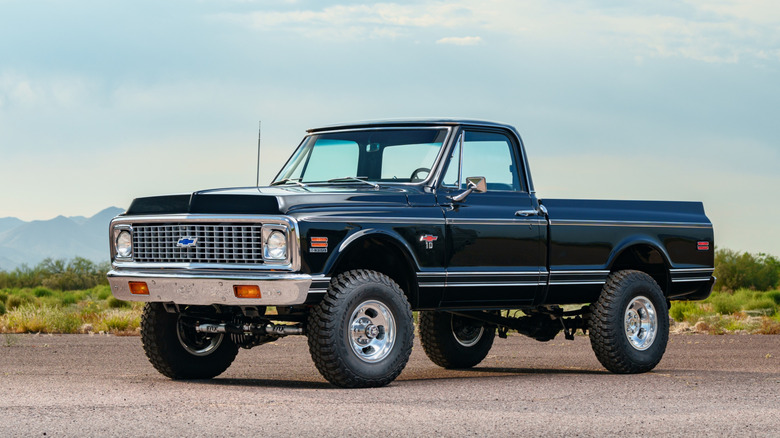 A fully restored Chevy K10 against a hilly landscape