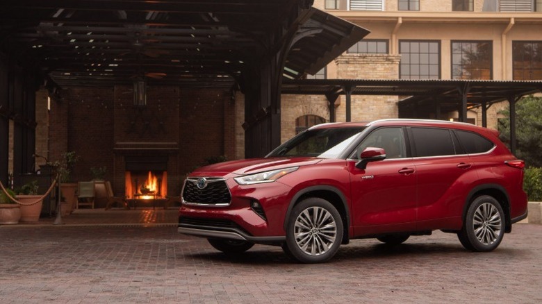 A red 2020 Toyota Highlander in front of a home