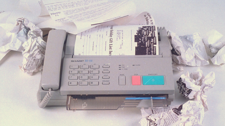 Crumpled paper around telephone fax machine