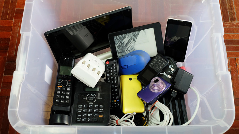 Used modern electronic gadgets in clear plastic box.