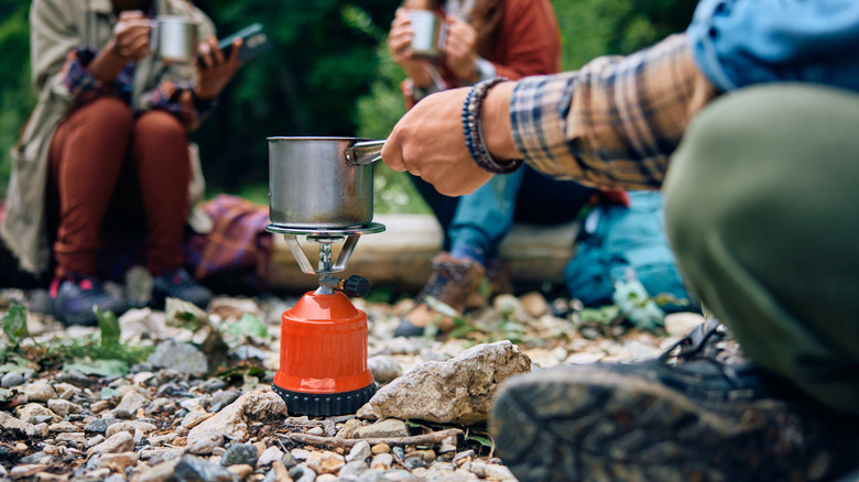 Group of people around a portable camping stove
