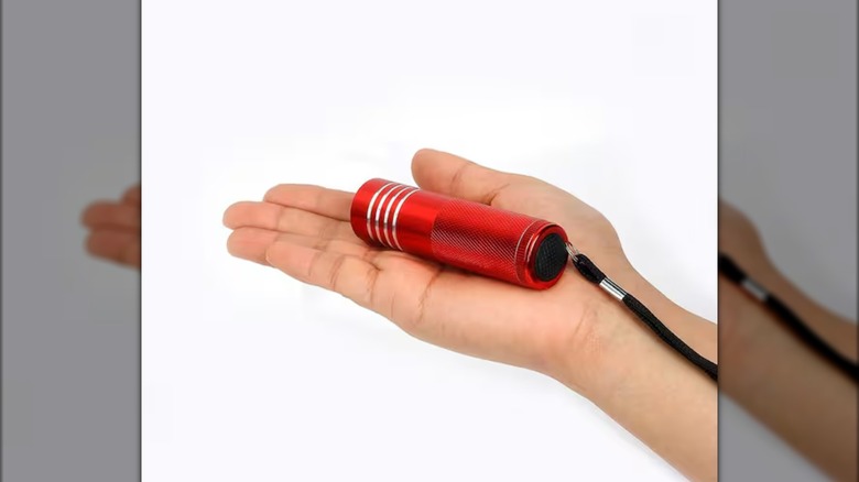 hand holding a Defiant flashlight