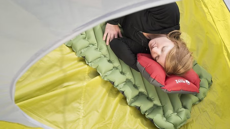 Camper sleeping on a Klymit pad inside a tent