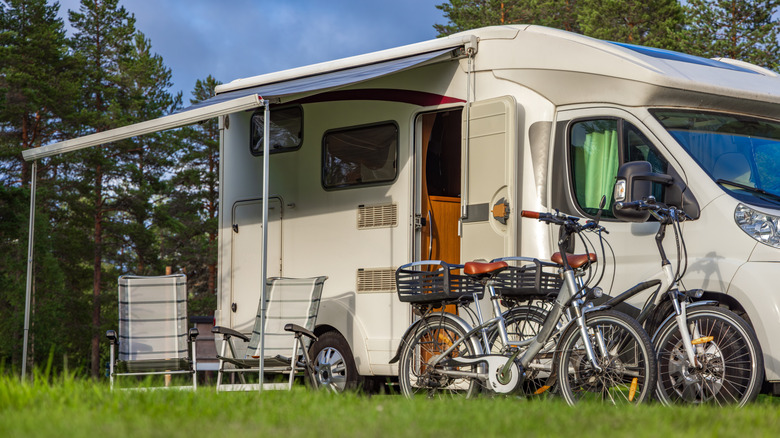 Two bicycles and chairs placed outside an RV.
