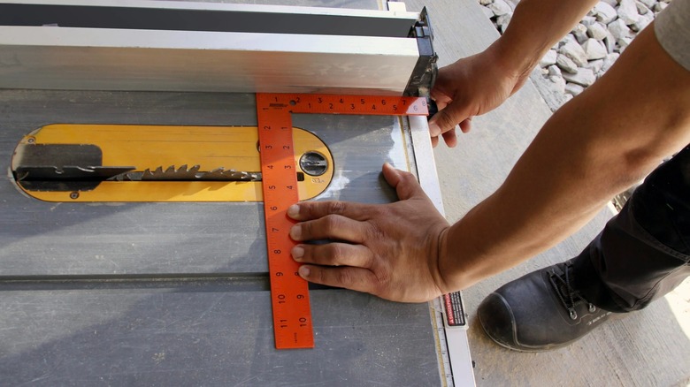 Person using Johnson Level carpenter square on table saw.
