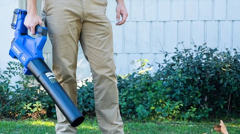 A person using Kobalt leaf blower in a yard.