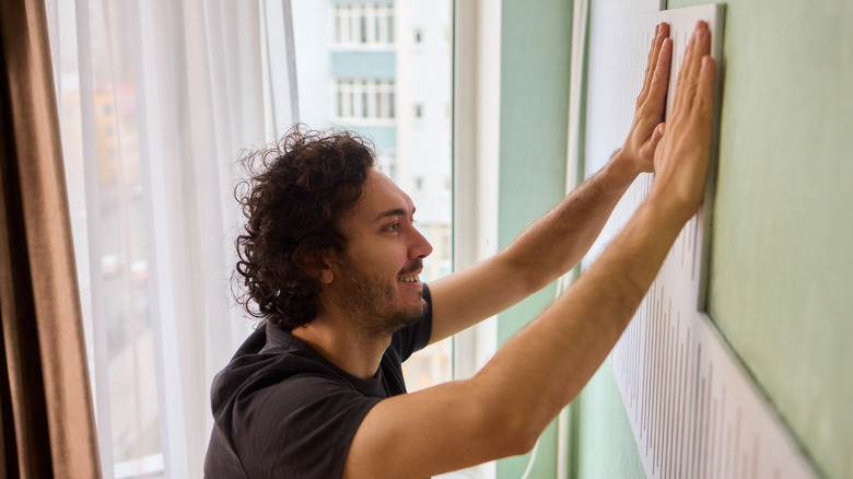 A man installing acoustic panels in his home