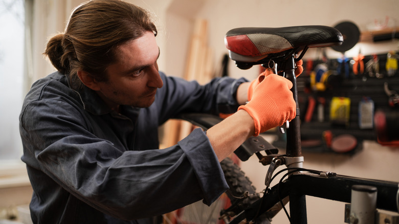 A mechanic working on a bicycle seat in a workshop