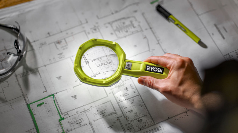 The LED Magnifying Light held over building plans.