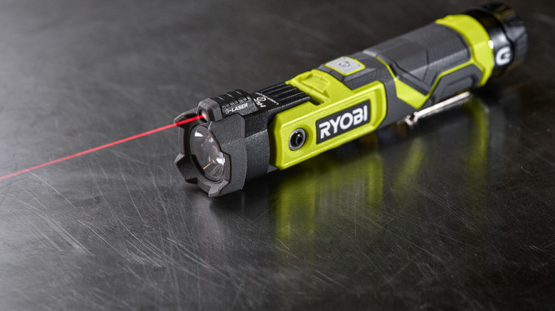 A Ryobi LED Pivoting Laser on a table with the laser on.