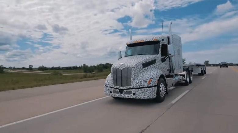 A covered Peterbilt 579 truck on a road