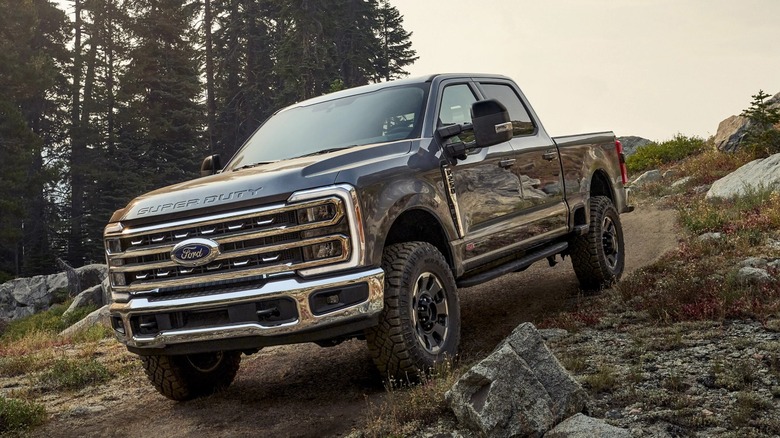 A black Ford F-250 super duty truck on a hilly road