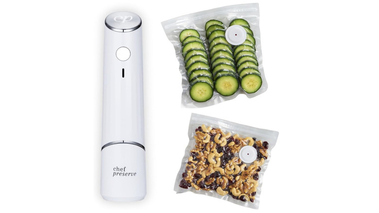 Stock photo of a handheld food vacuum with bags of various sealed foods