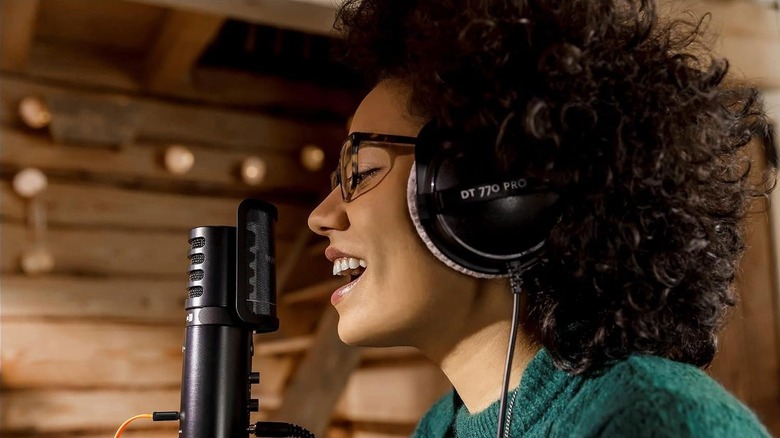 A person wearing a Beyerdynamic headphone while singing