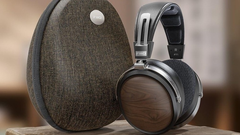 A FiiO headphone placed next to its carrying case