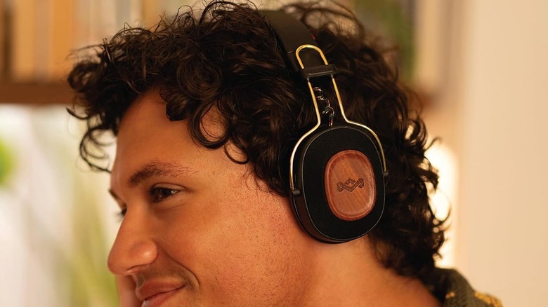 A person wearing a pair of House of Marley headphones
