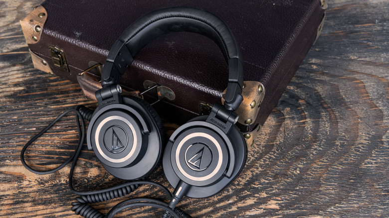 A pair of Audio-Technica headphones placed against a briefcase