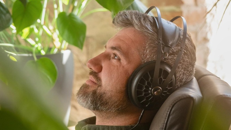 A person wearing headphones from Meze Audio while resting on the couch