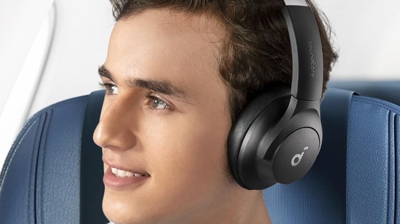 A person wearing Soundcore headphones on a flight