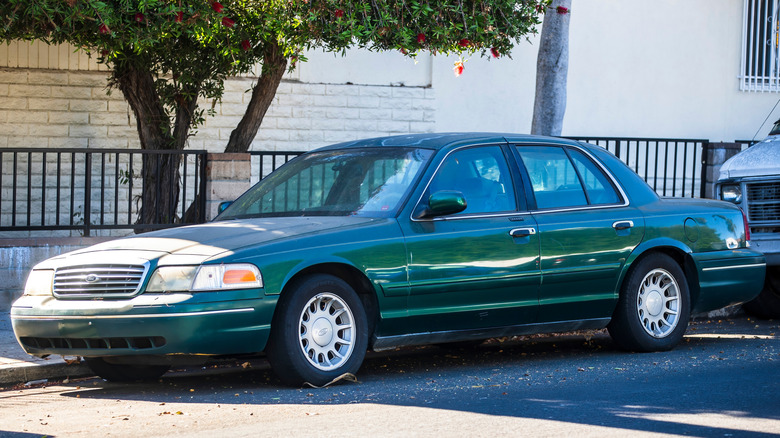 Green ford Crown Victoria parked on side of road