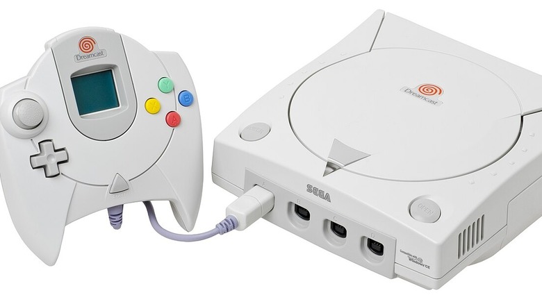 Sega Dreamcast with a controller plugged in, against a white background