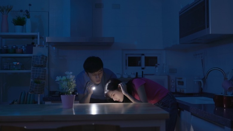 a couple looking for something in the dark