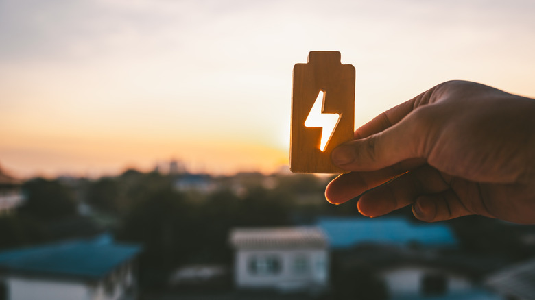 A person holding a symbol of electricity