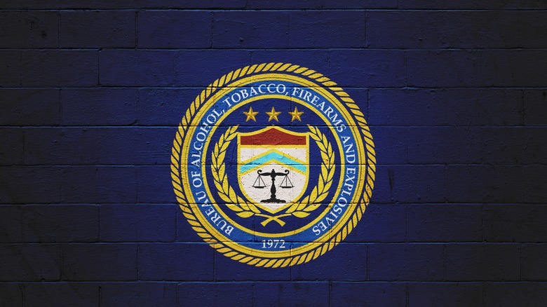 The logo of the Bureau of Alcohol, Tobacco, and Firearms on a navy blue wall.