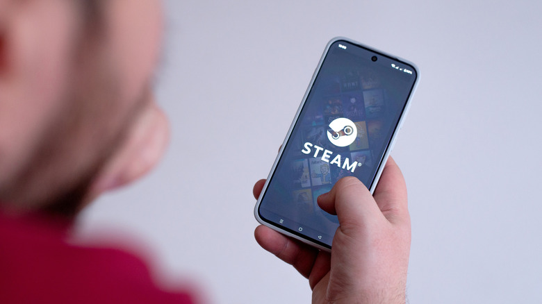 A person loading the Steam app on a smartphone.