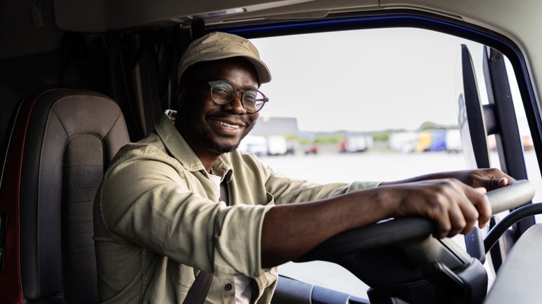 Truck driver in a truck cabin, smiling