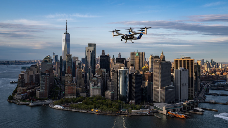 Joby air taxi flying over New York City, with Manhattan Island in the distance.