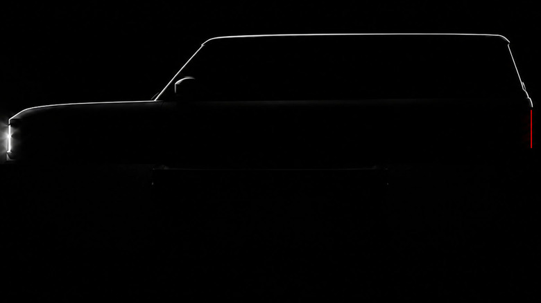 Side teaser view of REO Runabout SUV on black background.