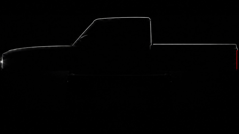 Side teaser view of REO Runabout pickup truck on black background.
