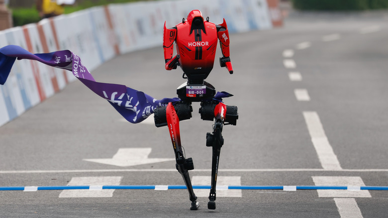 An Honor robot crossing a marathon finish line.