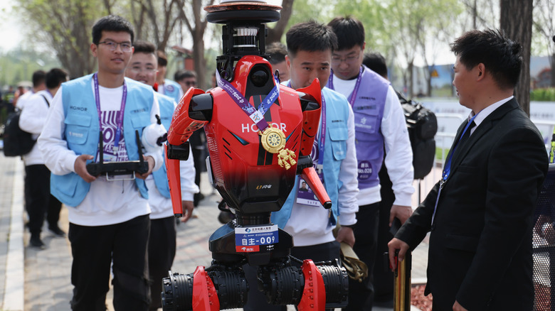 The Honor running robot wearing a medal.