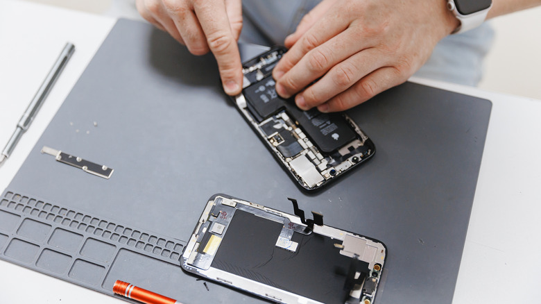 Service technician repairing a broken iPhone 16.