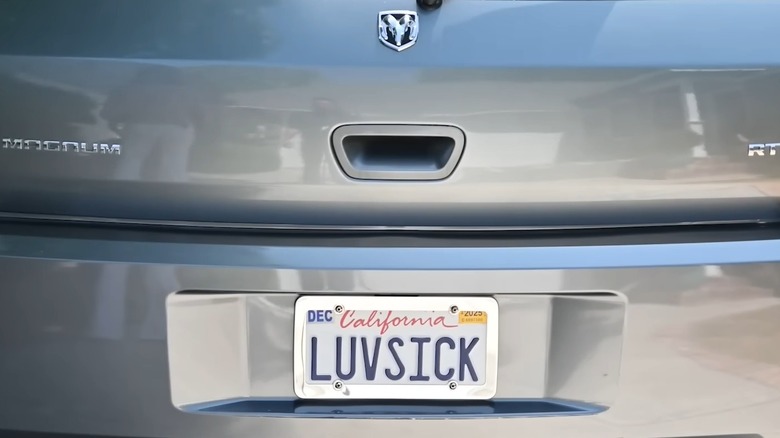 Close-up of California license plate with text "LUVSICK" on Dodge Magnum